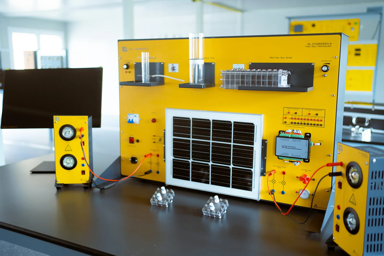 Entrenador didáctico de hidrógeno con panel solar, módulos de medición y celda de combustible sobre una mesa de laboratorio